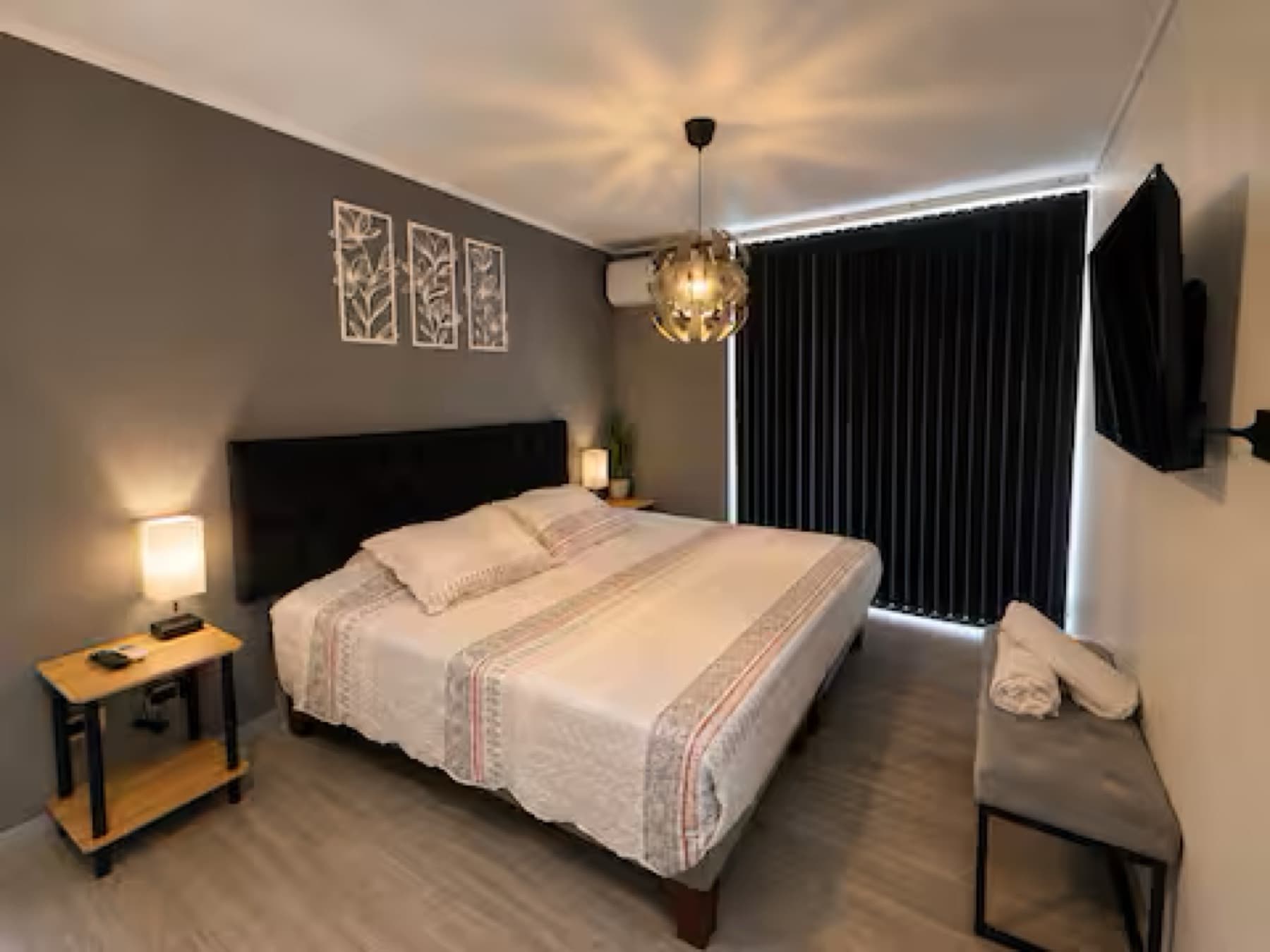 Dormitorio principal con cama de dos plazas, veladores y lámpara colgante