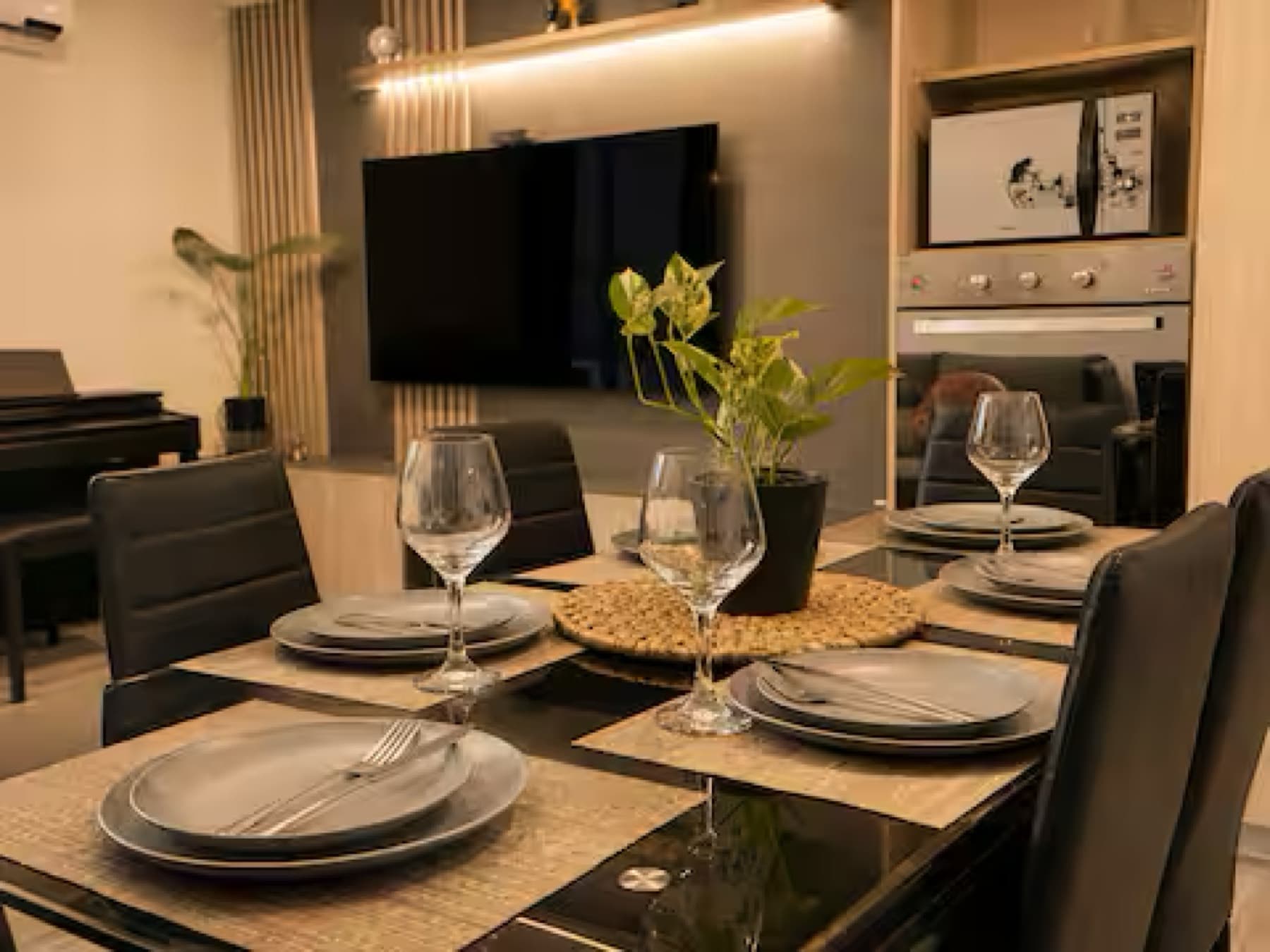 Mesa de comedor puesta para seis personas con copas y platos