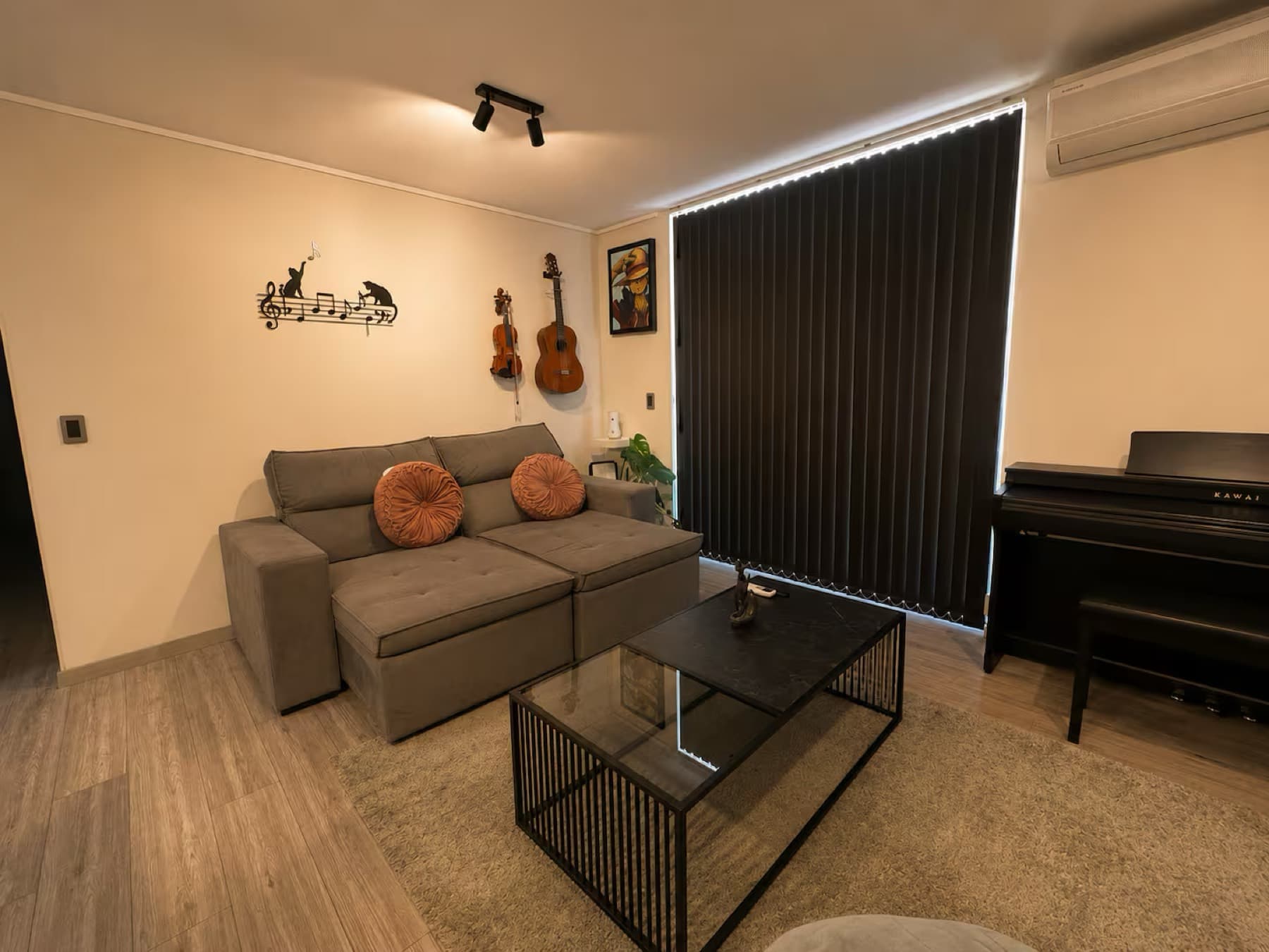 Living con sofá, piano e instrumentos en un departamento administrado por Luxel