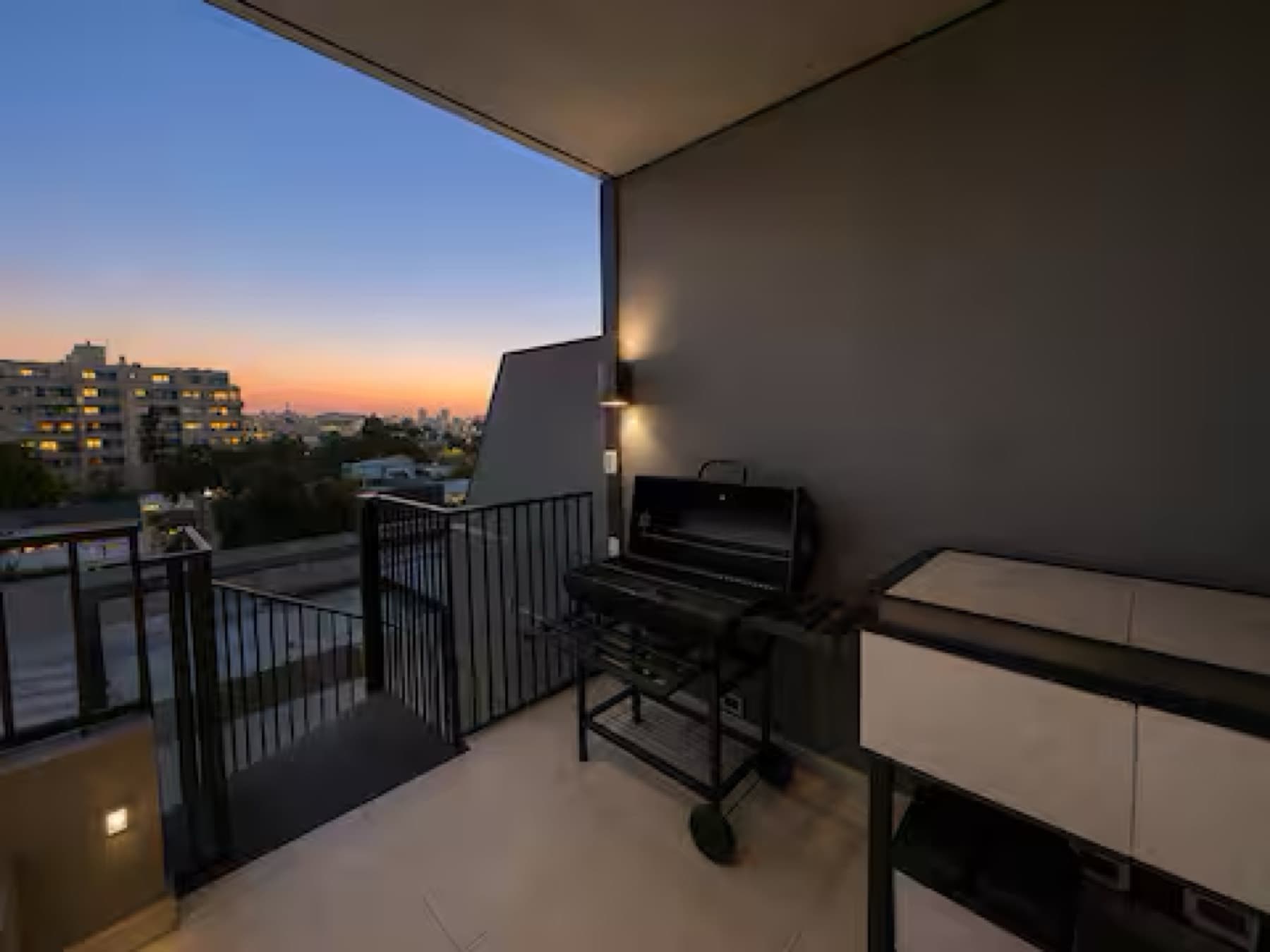 Terraza con parrilla y vista al atardecer en un departamento administrado por Luxel
